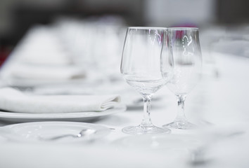 White empty plates and glasses served on a table for a celebration