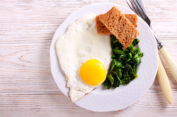 Fried egg and spinach on plate
