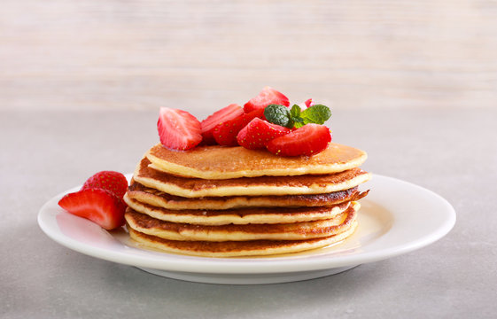 Pile of pancakes with strawberry on plate