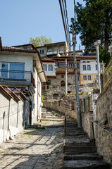Fototapeta na wymiar Medieval streets of old town of Veliko Tarnovo, old capital of Bulgaria. Cobbled street leads up to the top of the hill.