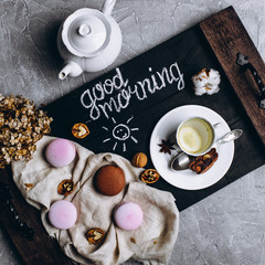 Wooden tray with a cup of tea and cookies