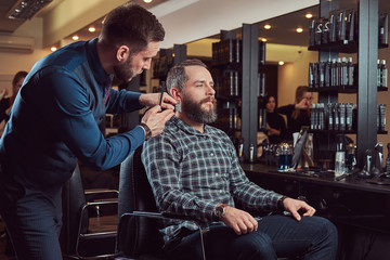Professional barber working with a client in a hairdressing salon.