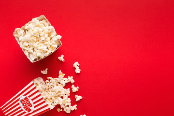 Bucket of popcorn on red background, top view