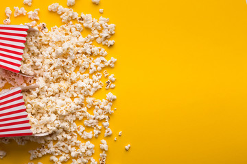 Buckets of popcorn on yellow background, top view