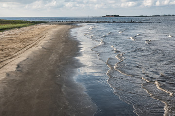 At Grand Isle, Louisiana, the channel entrance to Caminada and Barataria Bays with the ruins of Fort Livingston on Grande Terre Island in the background.