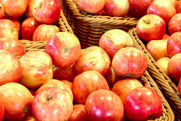 Ripe red and yellow apples in a wicker basket.