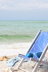 Fototapeta na wymiar toy deckchair at beach at background with ocean sea stars relax