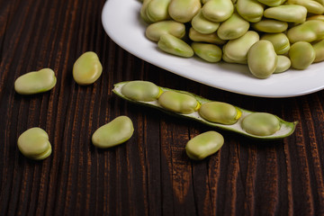 fresh broad beans on a rustic background