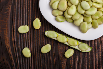 fresh broad beans on a rustic background