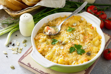 Casserole crumble with red fish, white bread and cheese on stone or slate background. Proper nutrition. Healthy lifestyle.