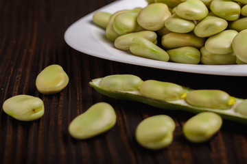 fresh broad beans on a rustic background