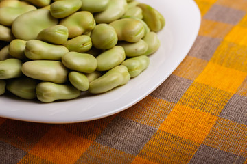 fresh broad beans on a rustic background