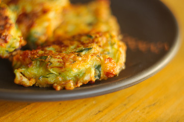 Fried vegetable fritters with zucchini, carrots, herbs, eggs, and cheese.