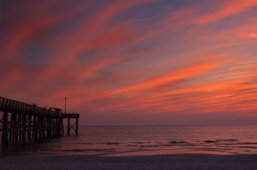 Fototapeta na wymiar Fishing pier with sky ablaze