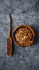 Flatlay with healthy sweets cooking ingredients: granola, sesame and flax seeds, cocoa in separate bowls on gray background