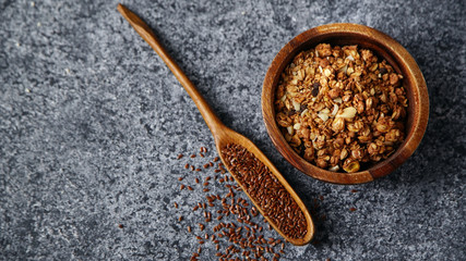 Healthy sweets cooking ingredients: granola, sesame and flax seeds, cocoa in separate bowls on gray background. Flatlay with copy space