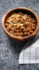 Granola in wooden bowl on gray background. Flatlay with copy space