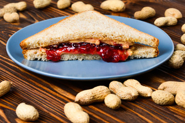Peanut butter and jelly sandwich on wooden background. Space for text or design.