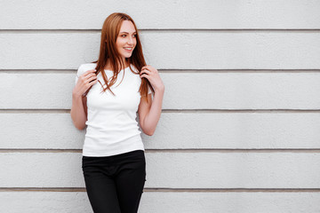 Fototapeta premium Girl against street wall, minimalist style.