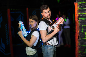 Two laser tag players standing back to back