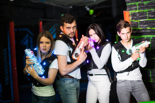 Young people with laser guns on lasertag arena