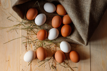 Fresh, raw eggs lie on the grass. Wood background. Texture of burlap. Organic background. Healthy...