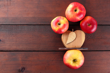 Fruits of oranges and red apples on a dark brown wooden background, halves of oranges on wooden boards. Copy space. Citrus fruits and apples for vegetarian breakfast
