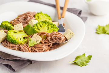 Vegetarian Soba Noodles with tofu and broccoli, white background. Healthy vegan food concept.