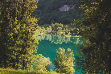 Lago di tenno with mountain and trees reflection in water. Tenno, Privincia di Trento, Trentino0Alto Adige, Italy