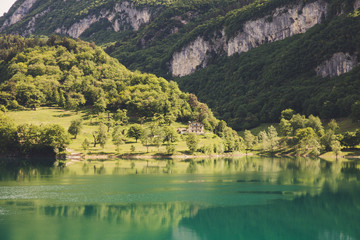 Fototapeta na wymiar Lago di tenno with mountain and trees reflection in water. Tenno, Privincia di Trento, Trentino0Alto Adige, Italy