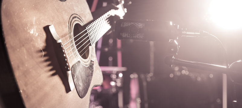 The Studio microphone records an acoustic guitar close-up. Beautiful blurred background of colored lanterns.
