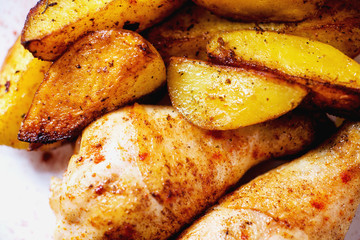 a tasty dish for the holiday, a new year or Christmas, baked potatoes with chicken legs, spices, paprika, sesame, bagel, olive oil, red wine on a wooden background