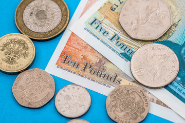 British Pound money bills and coin on blue