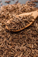 Seeds of cumin on a dark stone background