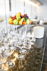 many wineglasses. Breakfast in restaurant of hotel. Plate with fruits and berries on a smorgasbord in the background. Bar