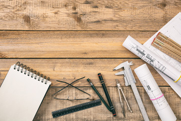 Architect workplace. Project construction blueprints and engineering tools on wooden desk, copy space