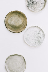 Handmade plates on white background. Flat lay, top view artist minimal concept.