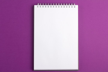Blank notebook on purple background. Flat lay concept