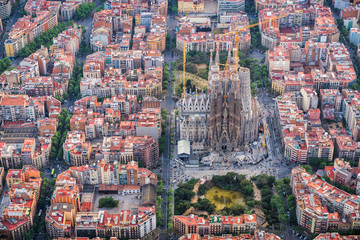 Fototapeta premium Barcelona z lotu ptaka, dzielnica mieszkaniowa Eixample i Sagrada Familia, Hiszpania. Światło późnego popołudnia