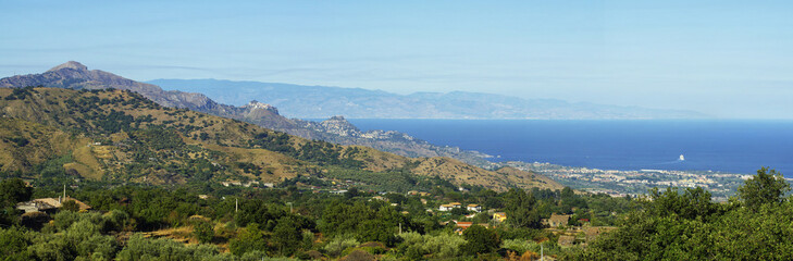 Fototapeta na wymiar The pictures landscape of Sicily coast with Castelmola, Taormina and Giardini Naxos towns view in the background.Sicily, Italy