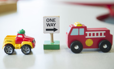 A One Way is shown next to a childs toy cars