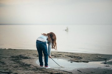 girl is playing in the puddle near the sea
