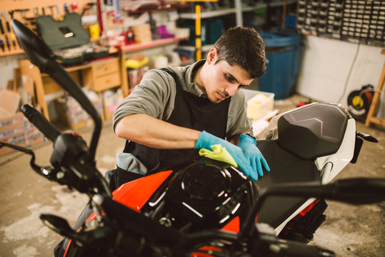 Mechanic polishing and cleaning a motorcycle