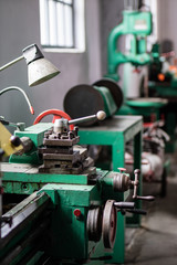 Old hard lathe in a workshop. Machine park in the locksmith's workshop.