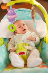 Adorable baby boy two months old rests in a chair