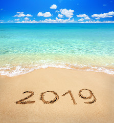 2019 written on sandy beach