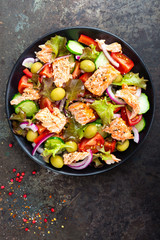 Salad with fish. Fresh vegetable salad with salmon fish fillet. Fish salad with salmon fillet and fresh vegetables on plate