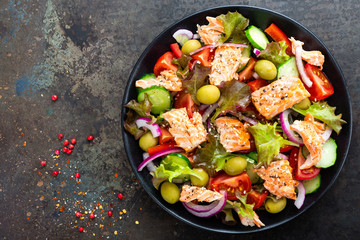 Salad with fish. Fresh vegetable salad with salmon fish fillet. Fish salad with salmon fillet and fresh vegetables on plate