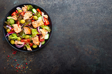 Salad with fish. Fresh vegetable salad with salmon fish fillet. Fish salad with salmon fillet and fresh vegetables on plate