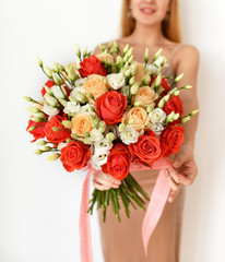 Beautiful woman hold bouquet of red and pink roses flowers happy smiling on grey 